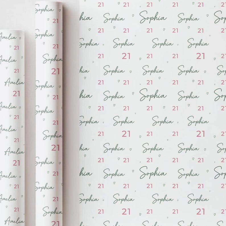 May include: White wrapping paper with a repeating pattern of the name "Sophia", the number "21", and small pink hearts. Rolled paper on the left shows the name "Amelia" and the number "21".