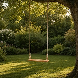 May include: A rectangular wooden swing seat suspended by two thick, braided beige ropes. The ropes are securely knotted around a sturdy tree branch. The seat is made of smooth, light-toned wood with a natural finish, hanging level above the grass.