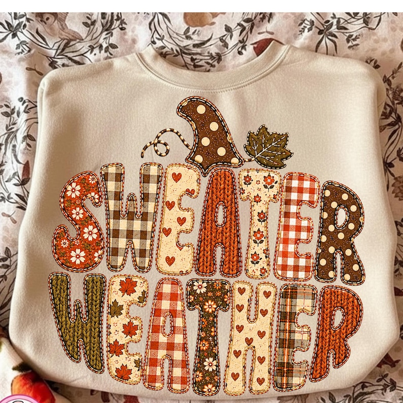 Puede incluir: Una sudadera de cuello redondo en color beige con un gran gr&aacute;fico en forma de calabaza que contiene el texto "SWEATER WEATHER". Las letras est&aacute;n decoradas con varios patrones que incluyen cuadros, flores, lunares y texturas de punto en tonos oto&ntilde;ales.