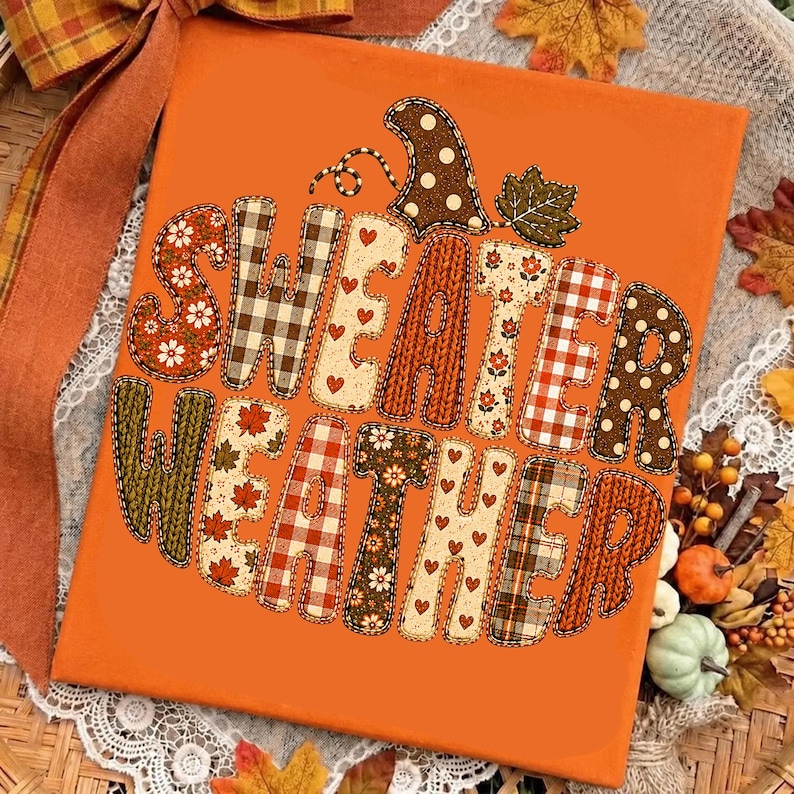 Puede incluir: Un lienzo rectangular naranja con el texto SWEATER WEATHER en letras grandes. Cada letra est&aacute; rellena con varios patrones que incluyen cuadros, flores, corazones y texturas de punto, con un tallo de calabaza y una hoja en la parte superior.