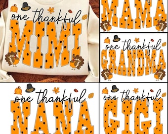 May include: A cream-colored sweatshirt featuring the text one thankful MIMI in large orange letters with black polka dots. The design includes illustrations of a pumpkin, a pilgrim hat, autumn leaves, an acorn, and two turkeys on the sides.