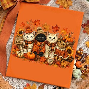 May include: An orange canvas print featuring four kittens wearing autumn-themed sweaters and scarves, surrounded by pumpkins, sunflowers, and fall leaves. A wooden sign reads HELLO FALL and a mug is labeled PUMPKIN SPICE, all in a warm color palette.