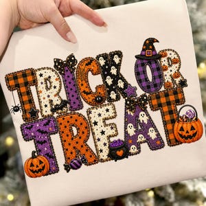 Könnte beinhalten: Eine weiße Stoffoberfläche mit dem Text TRICK OR TREAT in großen, gemusterten Buchstaben. Die Buchstaben enthalten orange-schwarze Karos, lila-schwarze Karos und weißen Stoff mit schwarzen Sternen, Geistern, Kürbissen und Schleifen.