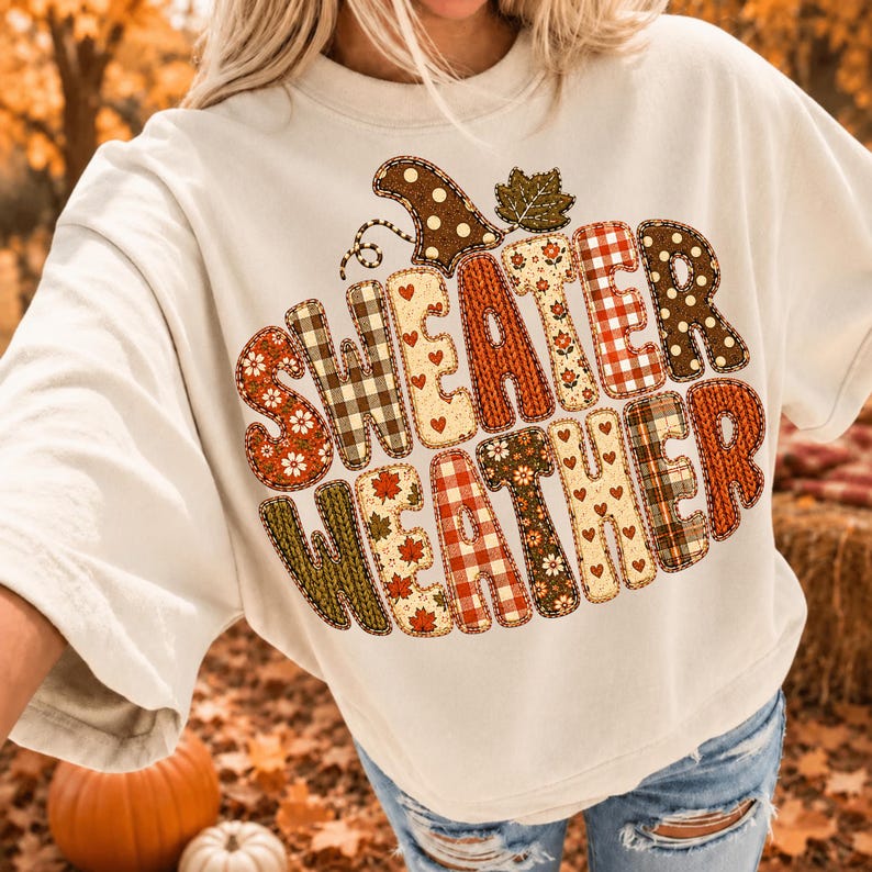 Puede incluir: Una camiseta de manga corta color crema con el texto "SWEATER WEATHER" en letras grandes y gruesas. Cada letra est&aacute; rellena con un patr&oacute;n oto&ntilde;al diferente, incluyendo cuadros, lunares, corazones, hojas y estampados florales en tonos c&aacute;lidos.