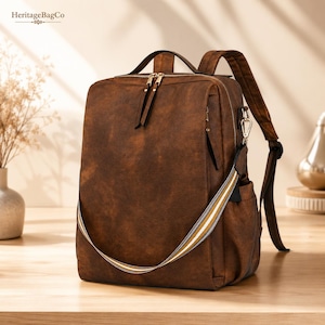 May include: A dark brown backpack with a weathered texture, featuring a top handle, adjustable shoulder straps, and a detachable crossbody strap with white and yellow stripes. The bag has gold-tone metal zippers and a rectangular silhouette.
