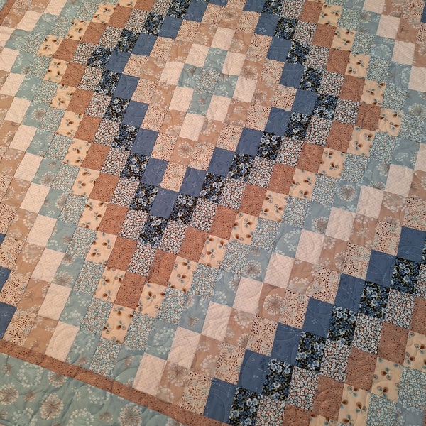 Homemade lap quilt in blues and tans, and brown