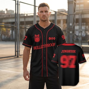 May include: A black baseball jersey with red trim, featuring the text "BULLETPROOF" and a BTS logo on the front. The sleeves display the number "97" in red. The back of the jersey shows the name "JUNGKOOK" above the large red number "97".