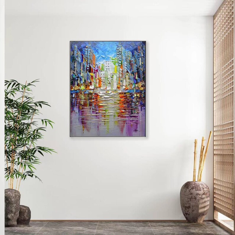 Puede incluir: Una pintura abstracta colorida de un horizonte urbano reflejado en una masa de agua. La pintura est&aacute; realizada en un estilo impasto grueso, con colores vibrantes y pinceladas audaces.