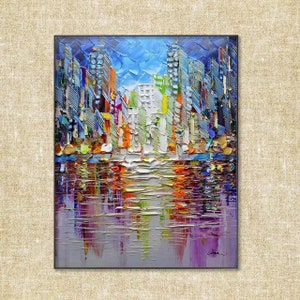 Puede incluir: Pintura abstracta de un horizonte urbano con edificios coloridos reflejados en una masa de agua. La pintura est&aacute; realizada en un estilo impasto grueso, lo que le da un aspecto texturizado.
