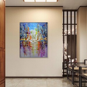 Puede incluir: Pintura abstracta de un horizonte urbano con edificios coloridos reflejados en el agua. La pintura est&aacute; realizada en un estilo grueso y texturizado con pinceladas visibles.