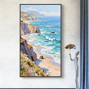 Puede incluir: Pintura al &oacute;leo enmarcada en negro que representa un paisaje costero. La obra muestra una playa con agua turquesa, acantilados y cielo azul. La pintura utiliza pinceladas gruesas y una paleta de azules, verdes y amarillos.
