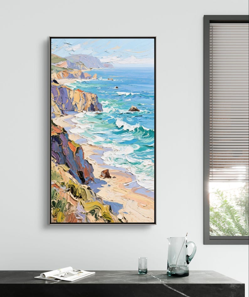 Puede incluir: Pintura al &oacute;leo enmarcada en negro que representa un paisaje costero. La obra muestra el oc&eacute;ano encontr&aacute;ndose con la orilla, con acantilados y olas en tonos de azul, turquesa y blanco. Los acantilados est&aacute;n pintados en tonos de naranja, morado y verde.