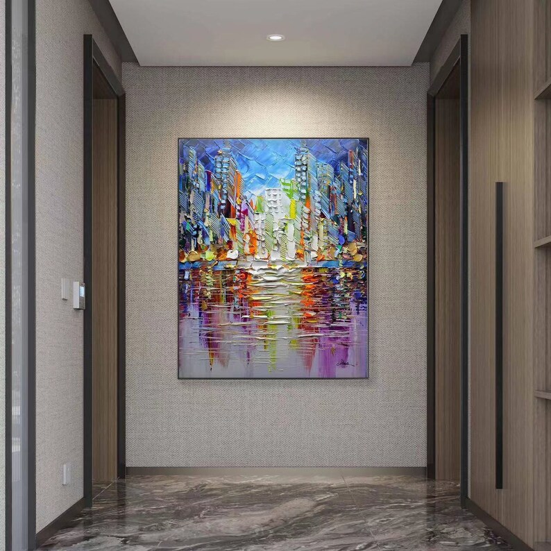 Puede incluir: Pintura abstracta de un horizonte urbano reflejado en el agua. La pintura presenta una variedad de colores, incluyendo azul, verde, amarillo, naranja y morado. Los edificios de la ciudad se representan de forma estilizada, casi caricaturesca.