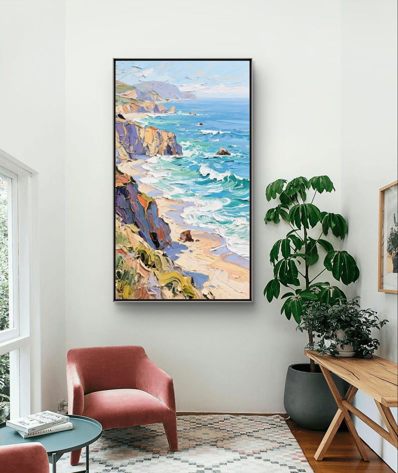 Puede incluir: Una pintura al &oacute;leo de un paisaje costero con acantilados, una playa y olas del oc&eacute;ano. La obra de arte tiene un marco negro y se exhibe en una pared blanca. La paleta de colores incluye azules, verdes, amarillos y marrones, creando una escena vibrante y texturizada.