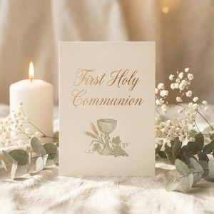 May include: A cream-colored card featuring the gold-foiled text First Holy Communion. Below the text is a detailed illustration of a chalice, wheat stalks, and grapes in muted green and gold tones, printed on high-quality textured cardstock.