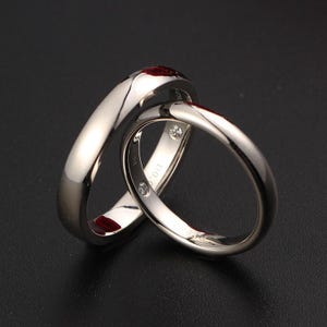 Conjunto de anillos entrelazados de Pt950 con rubí y diamante ocultos y cita de Virgilio.