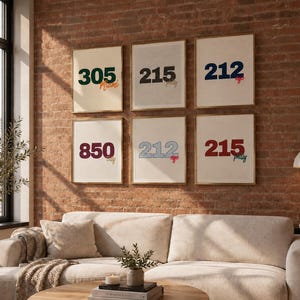May include: Six framed wall art prints featuring US area codes and city names. The prints display the numbers 305 Miami, 215 Philly, 212 NYC, 850 Tally, 212 NYC, and 215 Philly in various colors including dark green, black, navy blue, maroon, and red.