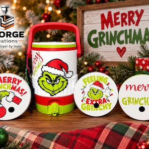 Puede incluir: Un enfriador de bebidas blanco y verde lima con asa roja y un gráfico del Grinch con gorro de Papá Noel. Se muestran tres tapas blancas circulares con ilustraciones del Grinch y el texto Merry Grinchmas y Feeling Extra Grinchy.