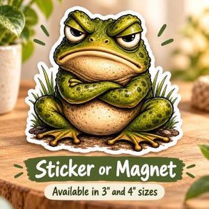 May include: A die-cut sticker or magnet featuring a grumpy green frog with a cream-colored belly, sitting with arms crossed. The text reads Sticker or Magnet and Available in 3" and 4" sizes. The frog has dark spots and a stern expression.