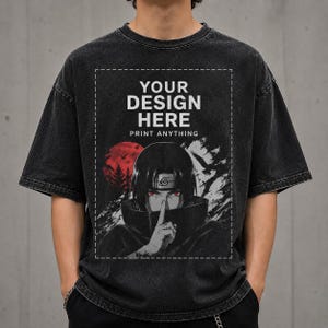 Peut inclure: Un t-shirt noir délavé à l'acide avec un imprimé graphique rectangulaire. Le texte YOUR DESIGN HERE PRINT ANYTHING surmonte l'illustration d'un personnage aux cheveux sombres, aux yeux rouges, portant un bandeau et un doigt sur ses lèvres.