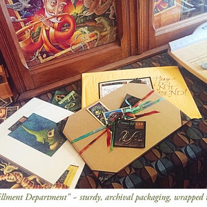 May include: A brown cardboard box with a colorful ribbon and a small tag that says "Corners for LAB". The box is sitting on a table with a patterned tablecloth. The text "Please Do Not Bend!" is written on a yellow piece of paper in the background.