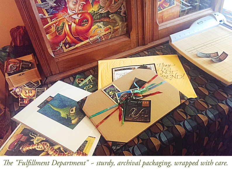 May include: A brown cardboard box with a colorful ribbon and a small tag that says "Corners for LAB". The box is sitting on a table with a patterned tablecloth. The text "Please Do Not Bend!" is written on a yellow piece of paper in the background.