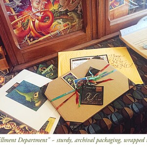 May include: A brown cardboard box with a colorful ribbon and a small tag that says "Corners for LAB". The box is sitting on a table with a patterned tablecloth. The text "Please Do Not Bend!" is written on a yellow piece of paper in the background.