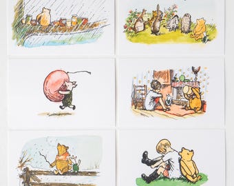 May include: A set of six rectangular cards featuring classic watercolour illustrations of Winnie the Pooh characters. Scenes include Pooh with honey pots in rain, the group in a meadow, Piglet with a balloon, Pooh and friends indoors, winter scenes, and Christopher Robin.