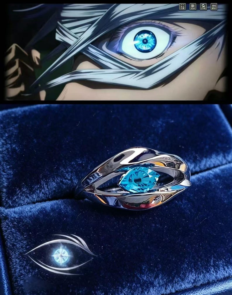 May include: A silver-toned metal ring featuring a polished, organic, eye-shaped band design that holds a single, brilliant, marquise-cut bright blue gemstone at its centre, reflecting light with a sharp, clear, and vivid azure colour.