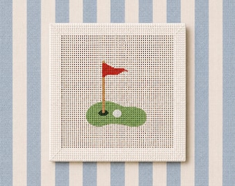 Puede incluir: Un lienzo cuadrado de punto de aguja con un diseño de campo de golf. El patrón muestra un green de golf, una pelota blanca y un asta con una bandera roja. El lienzo tiene una estructura de rejilla blanca y un borde blanco grueso y texturizado.