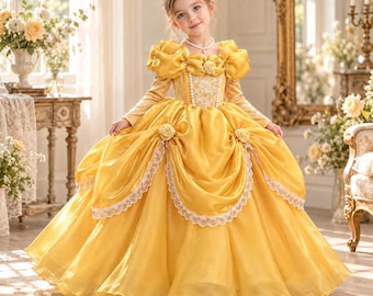 Puede incluir: Un vestido de gala amarillo hasta el suelo con mangas abullonadas caídas, un corpiño ajustado con adornos de perlas blancas y una falda voluminosa con capas de tela drapeada, bordes de encaje blanco y pequeñas rosas de tela.