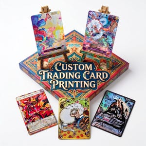 May include: Five custom trading cards featuring colorful anime-style illustrations, including two displayed on small wooden easels. The cards rest on a square box with the text Custom Trading Card Printing in a decorative font with gold accents.