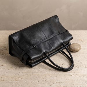 Top-down angle of the spacious black leather office handbag with the zipper open, revealing the roomy structured interior of this everyday work tote and crossbody purse.