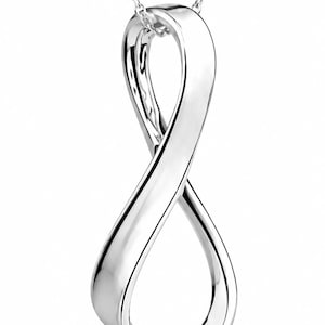 Pode incluir: Um pingente de metal prateado polido em forma de símbolo de infinito vertical, suspenso por uma delicada corrente prateada a condizer. A superfície metálica é lisa e reflexiva, criando um design de laço contínuo e fluido.