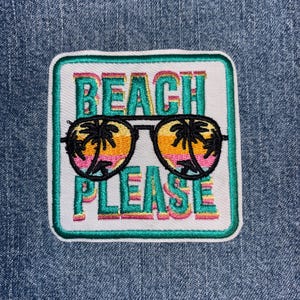 May include: A square embroidered patch on blue denim fabric featuring the text BEACH PLEASE in teal with a pink outline. Centered between the words is a pair of black-rimmed sunglasses with lenses showing a sunset scene with palm tree silhouettes.