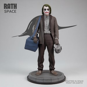 May include: A detailed statue of the Joker from The Dark Knight, featuring the character in a brown suit, gray shirt, and green hair. The figure holds a mask and a blue bag. The base reads "Crafted in Space Print on Earth."