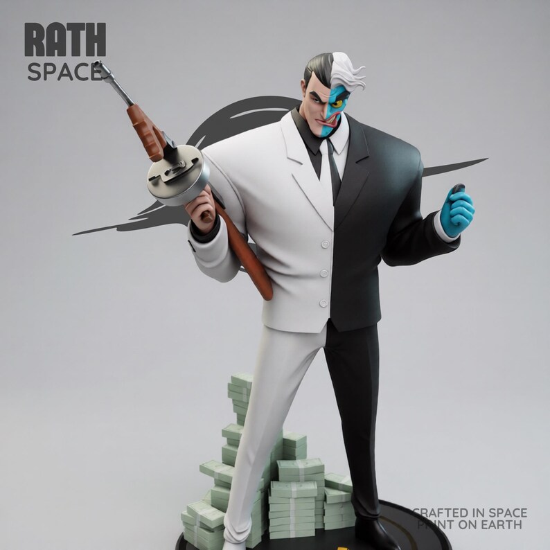 May include: A statue of the DC Comics villain Two-Face, split down the middle with a white and black suit. He holds a Tommy gun and stands on a base with stacks of money. The statue has the text "RATH SPACE" and "CRAFTED IN SPACE PRINT ON EARTH".