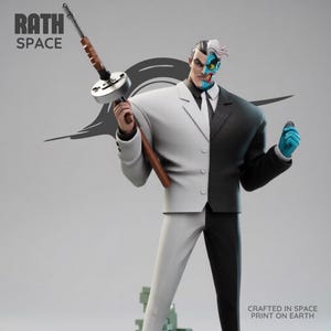 May include: A statue of the DC Comics villain Two-Face, split down the middle with a white and black suit. He holds a Tommy gun in one hand and a coin in the other. The statue has the text "RATH SPACE" and "CRAFTED IN SPACE PRINT ON EARTH".