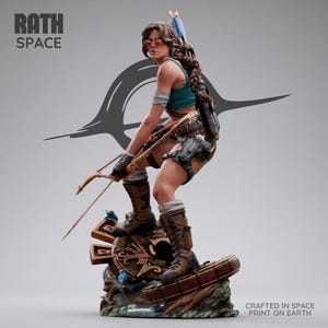 Puede incluir: Una figura detallada de una aventurera con una larga trenza castaña, vistiendo una camiseta sin mangas verde azulado, pantalones cortos marrones y botas altas. Sostiene un arco y flechas sobre una base tallada. Texto RATH SPACE y CRAFTED IN SPACE PRINT ON EARTH.