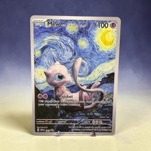 Op de afbeelding: Een Mew-verzamelkaart met een achtergrond geïnspireerd op De Sterrennacht, een gele maansikkel en een wervelende blauwe lucht. De kaart toont de naam Mew with The Starry Night, 100 HP, de Psyshot-aanval en de tekst G SVP 085 onderaan.