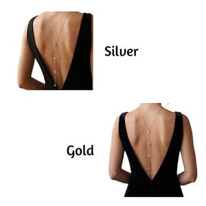 May include: A silver-toned back necklace and a gold-toned back necklace, each featuring a delicate chain with four evenly spaced circular accents. The necklaces are displayed against a black dress, with the text Silver and Gold labels present.