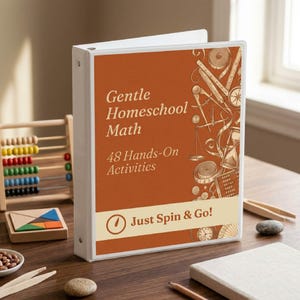 Könnte beinhalten: Ein weißer Ringordner mit einem rostorangen Einband, der den Text Gentle Homeschool Math, 48 Hands-On Activities und Just Spin & Go! trägt. Das Design enthält Illustrationen von mathematischen Werkzeugen wie einem Zirkel und einem Abakus.