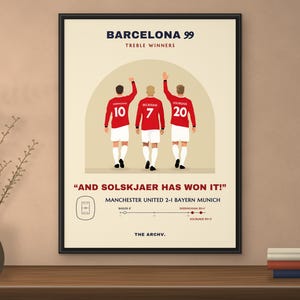 Framed poster of Manchester United 2-1 Bayern Munich, the 1999 Champions League final in Barcelona, hanging on a wall.