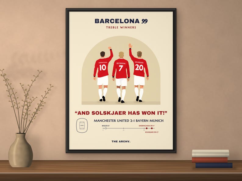 Framed poster of Manchester United 2-1 Bayern Munich, the 1999 Champions League final in Barcelona, hanging on a wall.
