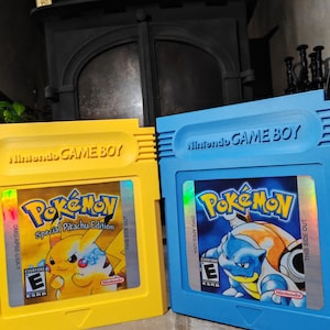 May include: Two Nintendo Game Boy video game cartridges. The yellow cartridge features Pikachu and the text Pokémon Special Pikachu Edition. The blue cartridge features Blastoise and the text Pokémon. Both include the Nintendo logo and ESRB E rating.