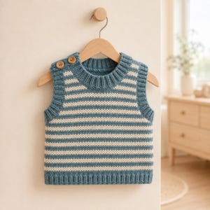 Può includere: Un gilet in maglia senza maniche con righe orizzontali blu e crema. Il capo presenta un girocollo a coste, giromanica a coste e un orlo a coste. Due piccoli bottoni in legno sono posizionati sulla spalla sinistra per la chiusura.