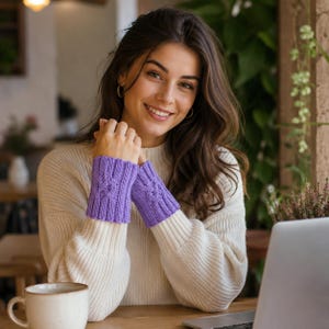 May include: A pair of lavender fingerless gloves featuring a ribbed knit texture and a central cable knit pattern. The gloves are crafted from yarn and extend from the wrist to the base of the fingers, providing a snug fit over the sleeves of a sweater.