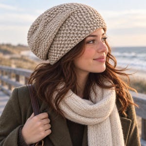 Puede incluir: Un gorro de punto beige con un patrón de puntadas en relieve y texturizado. El gorro presenta una silueta holgada y está confeccionado con hilo tejido suave. El diseño incluye una textura de rejilla repetitiva en toda la superficie del gorro.