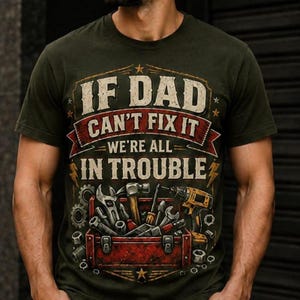 May include: An olive green t-shirt featuring a graphic print of a red toolbox filled with various metal tools, including a drill, wrench, and hammer. The text reads, "IF DAD CAN'T FIX IT WE'RE ALL IN TROUBLE," displayed in a distressed, vintage-style font.
