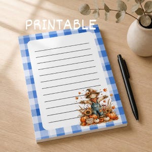Peut inclure: Un bloc-notes rectangulaire avec une bordure à carreaux vichy bleus et blancs et des lignes noires horizontales pour écrire. Le mot PRINTABLE est centré en haut. Une illustration d'épouvantail avec des citrouilles et des feuilles d'automne.